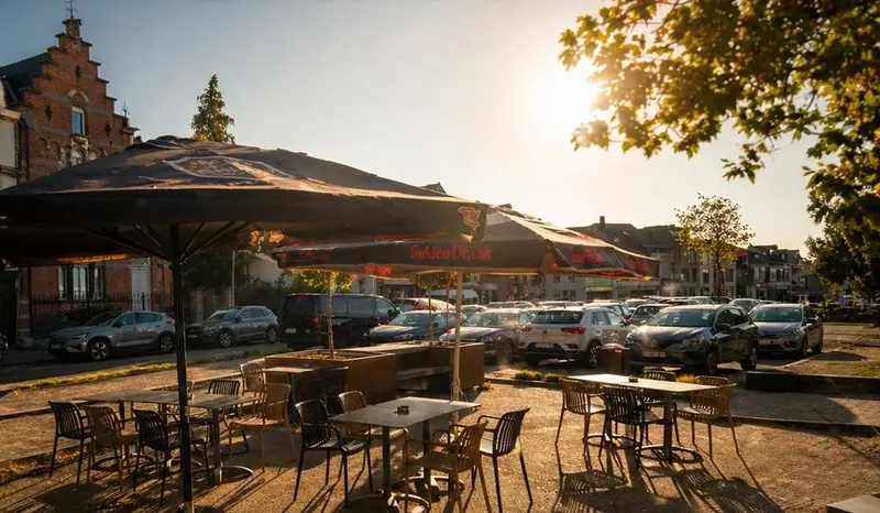 De Markt bij zonsondergang achter parasols en lege tafels.