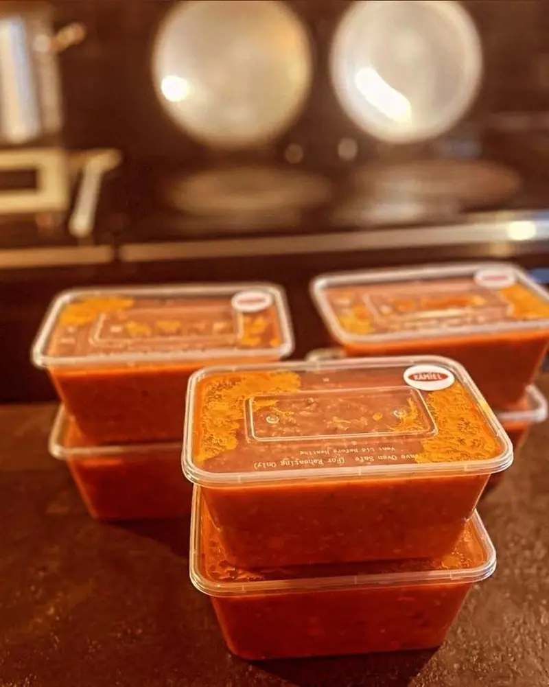 Vier bakjes saus op elkaar gestapeld voor het fornuis.